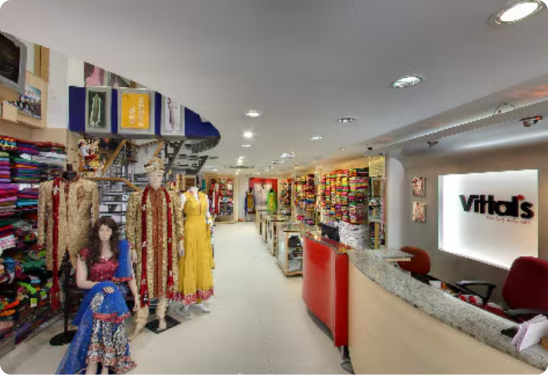 Interior of a store with mannequins wearing colorful outfits and a 'Vitals' sign.