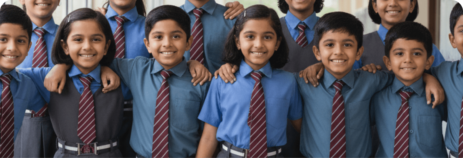 Group of children wearing blue shirts and red ties in a school setting